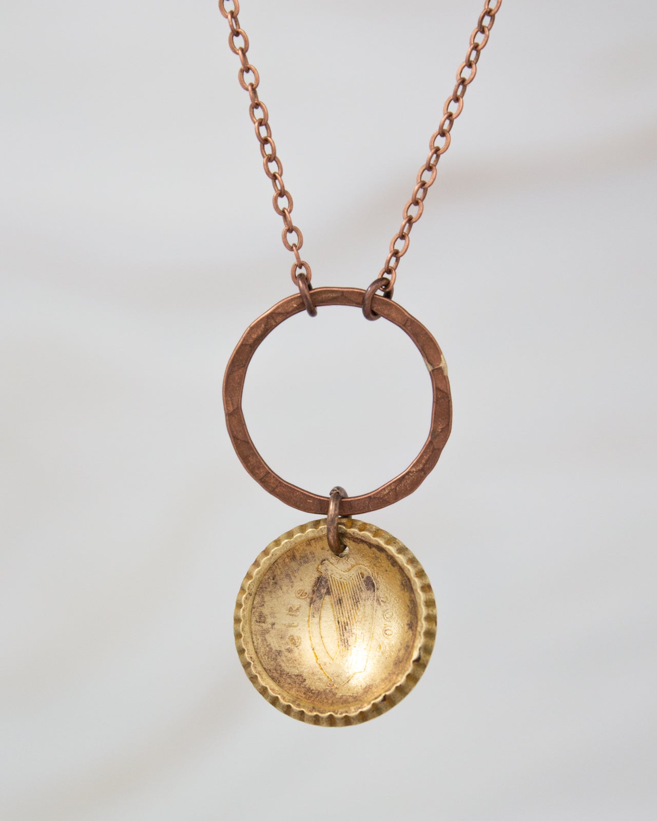 A necklace with a circular pendant featuring a design, hanging from a chain.