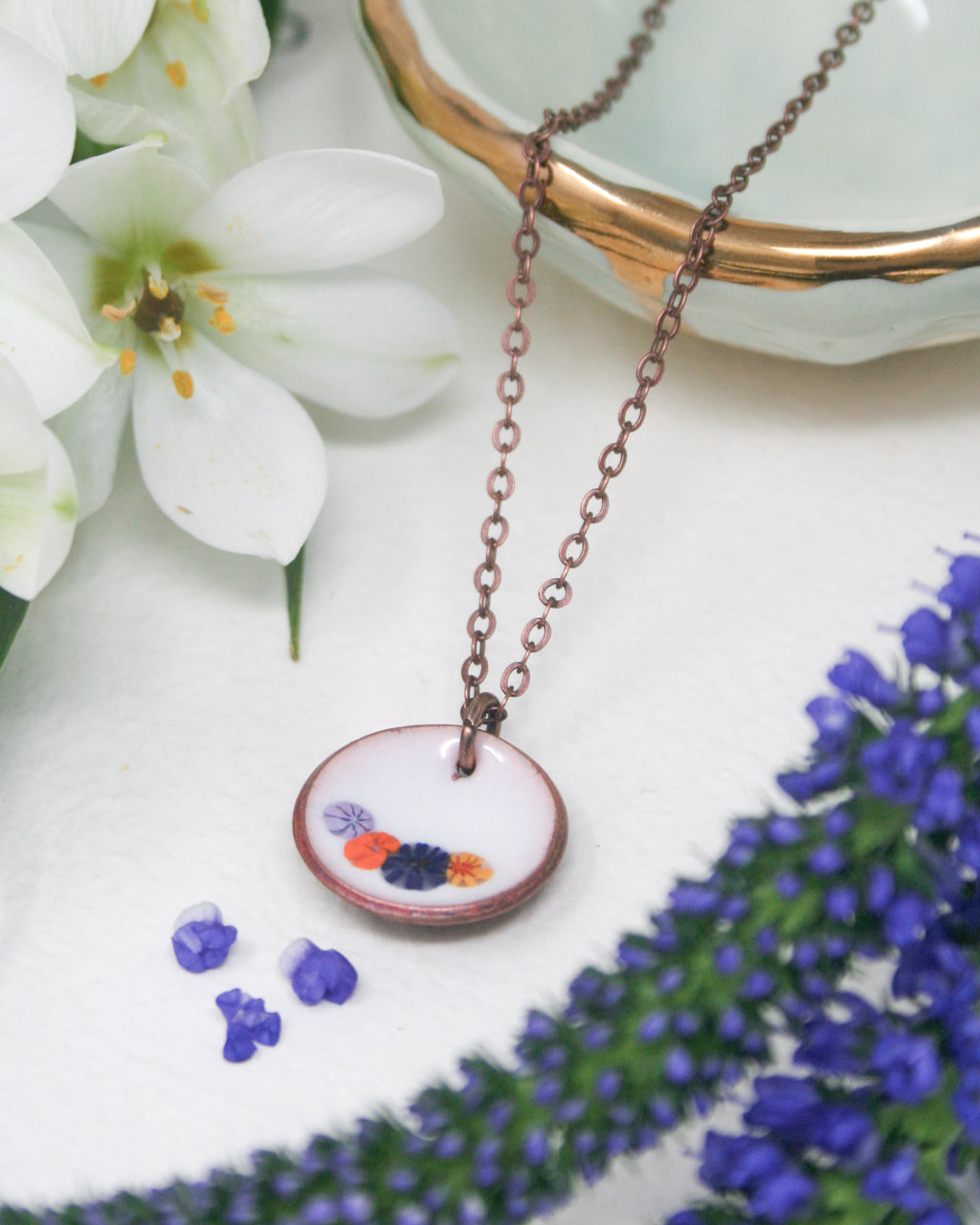 a necklace with a flower on it sitting on a table