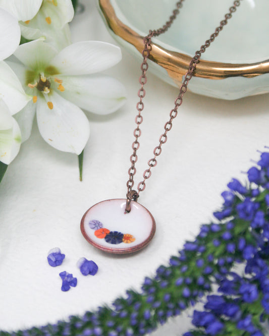 a necklace with a flower on it sitting on a table