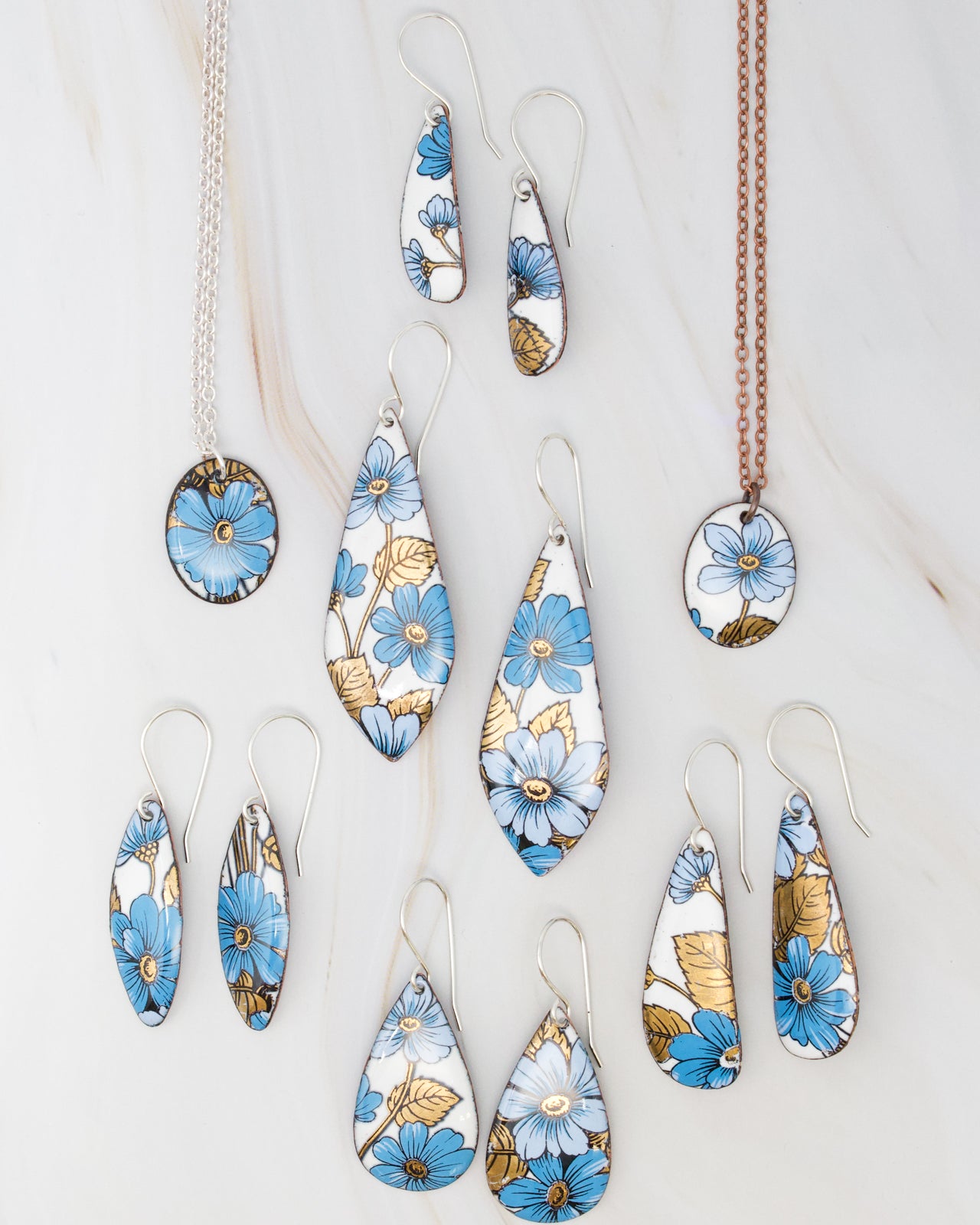a collection of jewelry pieces featuring blue and gold floral designs.