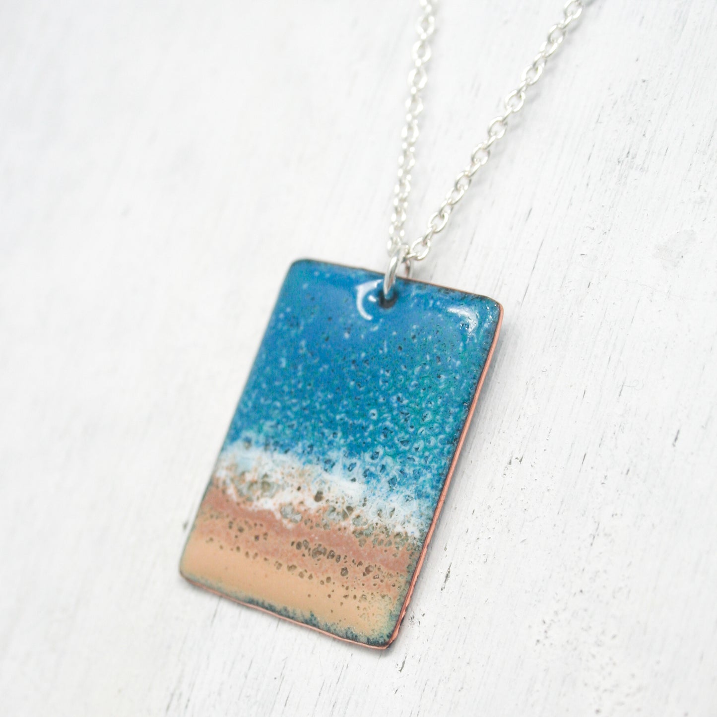 a necklace with a blue and orange design on it