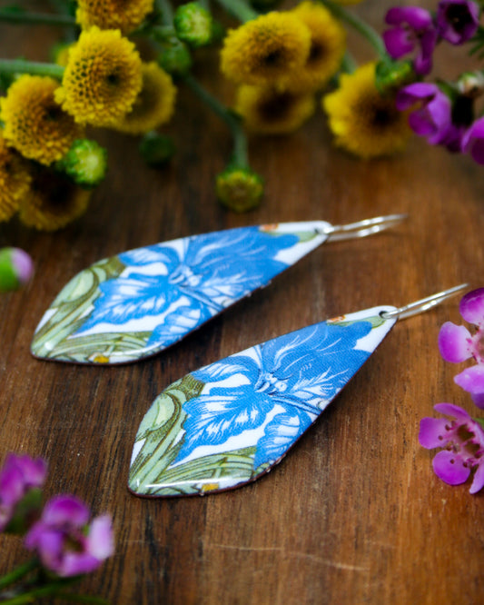 a pair of earrings sitting on top of a wooden table