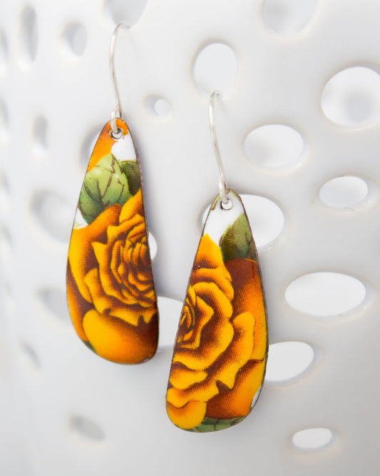 A pair of earrings with a floral design, featuring yellow and orange colors.