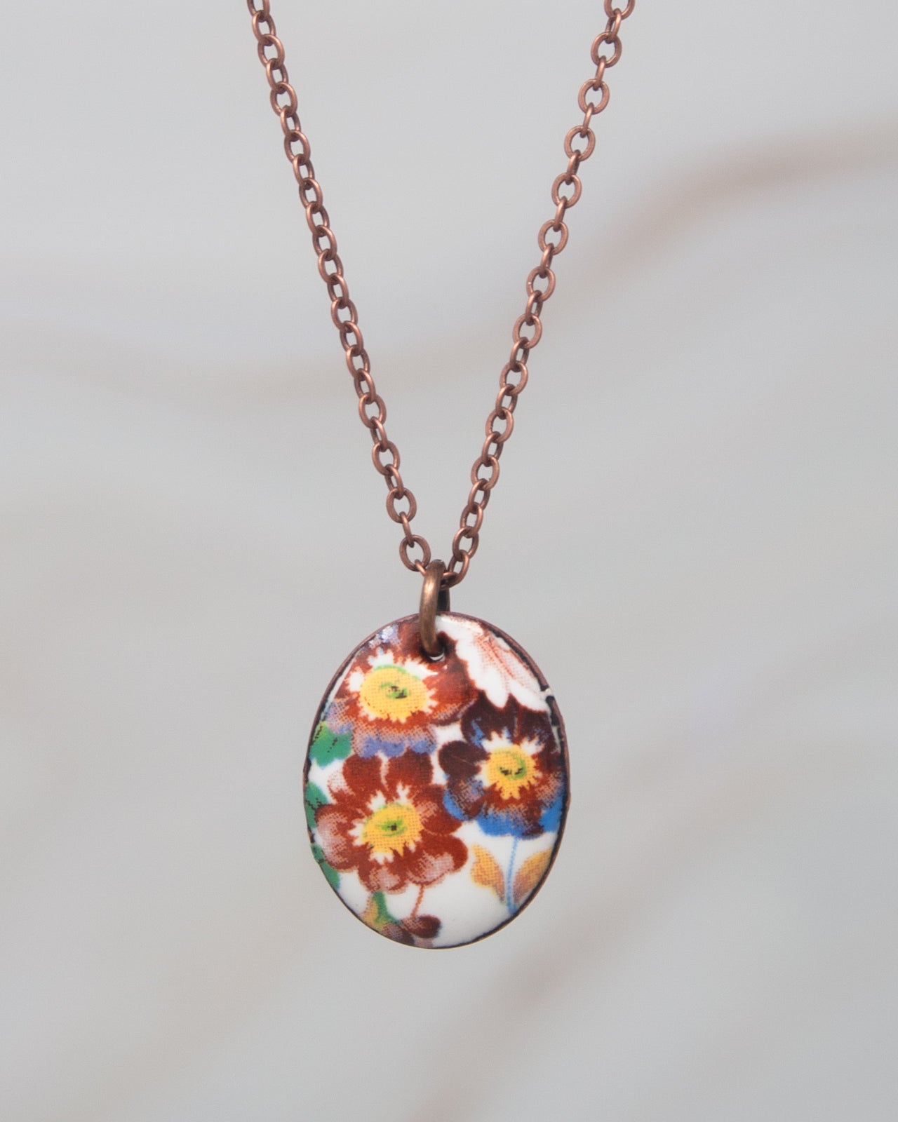 A necklace with a pendant featuring a colorful floral design.