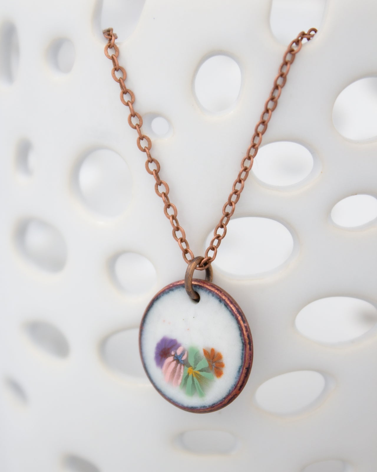 A necklace with a round pendant featuring a floral design.