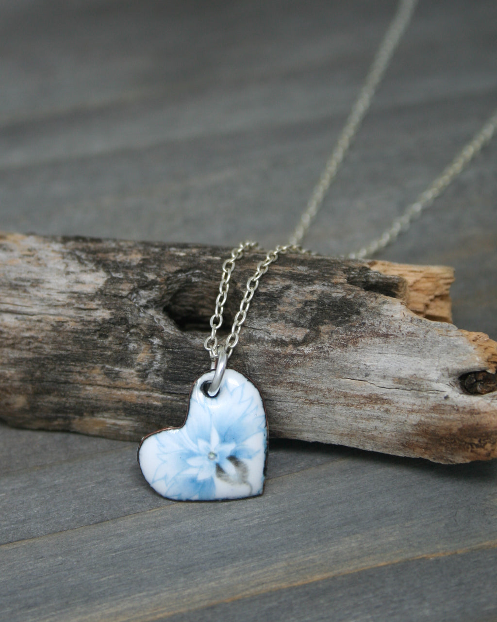 a small blue heart shaped pendant on a chain