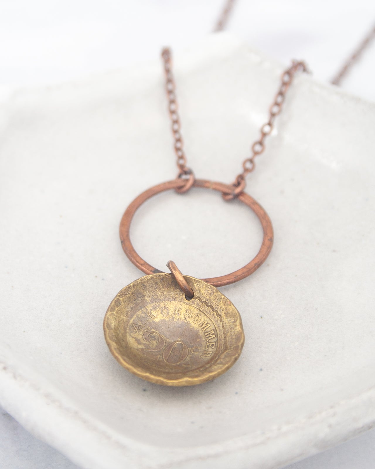 A necklace with a round pendant featuring a design, hanging from a chain.
