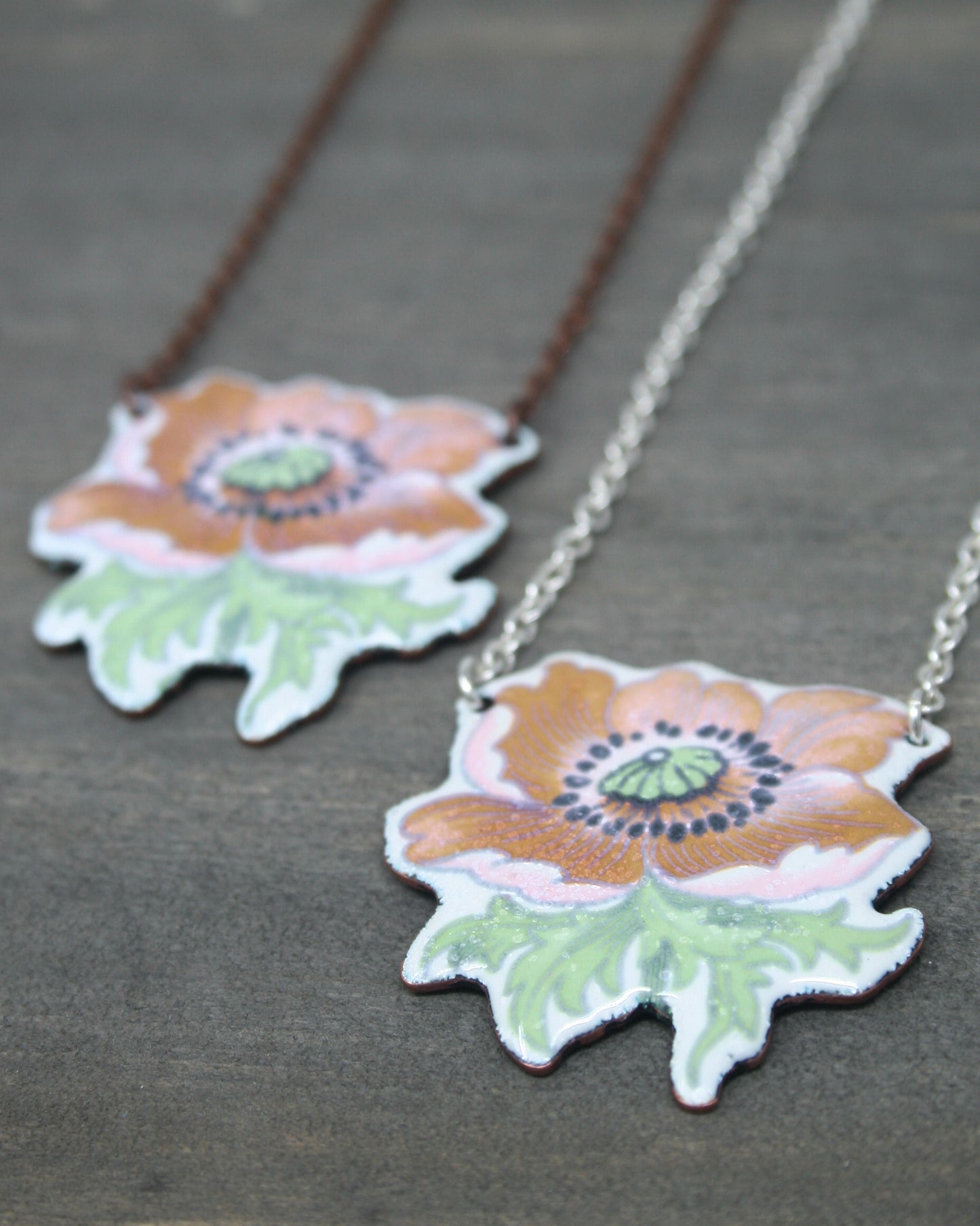 two necklaces with flowers painted on them