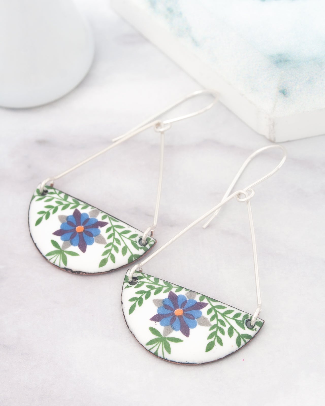 A pair of earrings with a floral design on a white background.