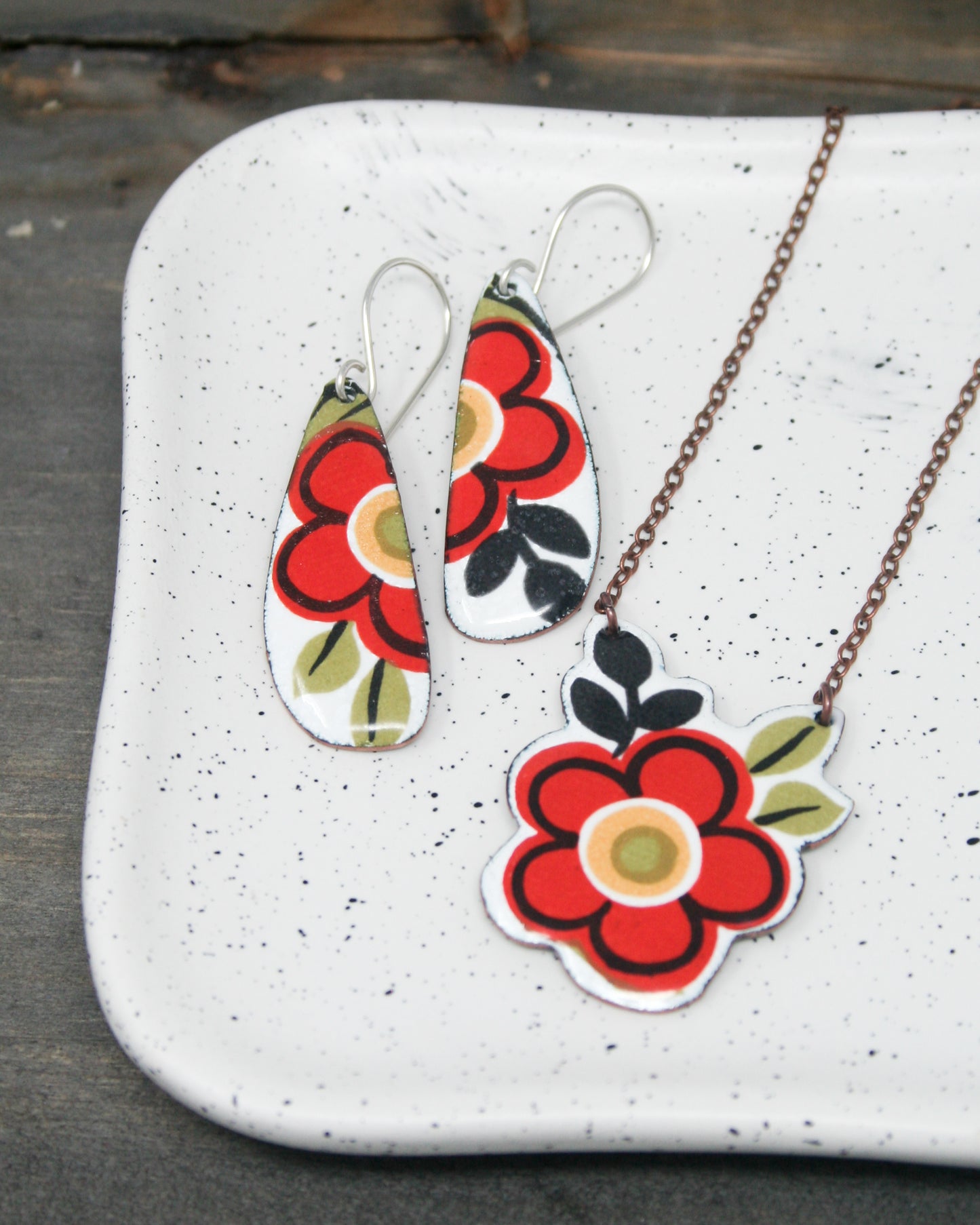 a white plate topped with two necklaces and a pendant