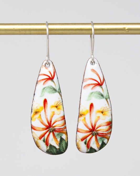 A pair of earrings with a floral design, featuring red, yellow, and green flowers on a white background.