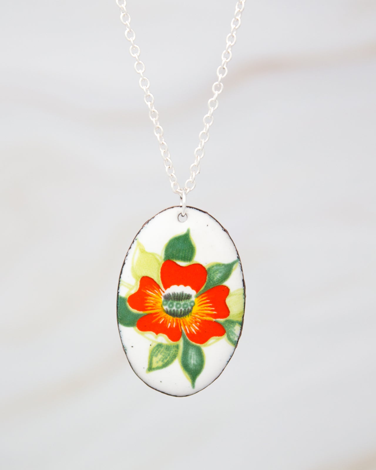 A necklace with a pendant featuring a colorful floral design.