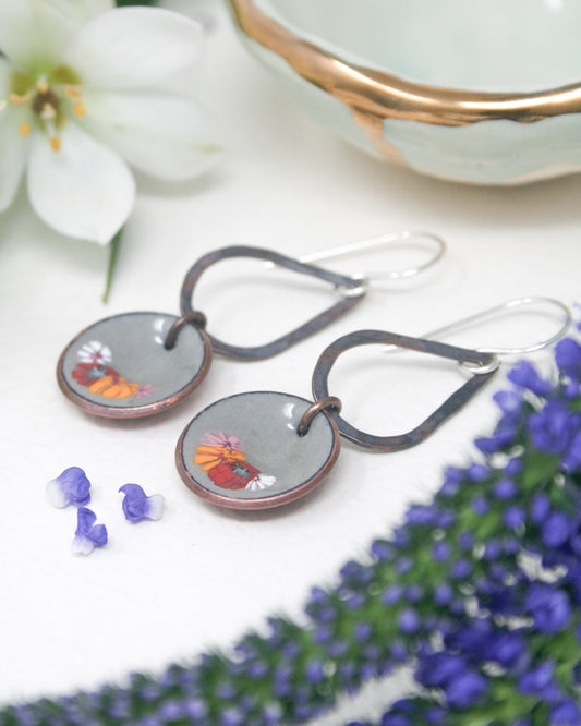 a pair of earrings sitting on top of a table