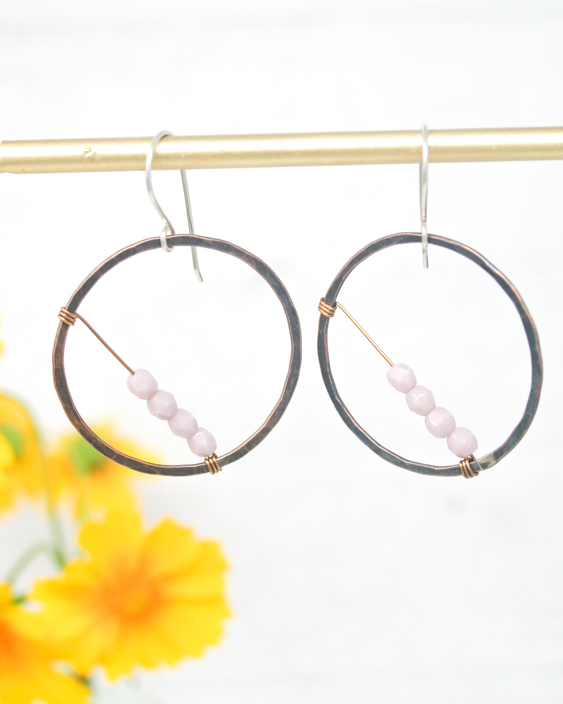 a pair of hoop earrings with beads hanging from them