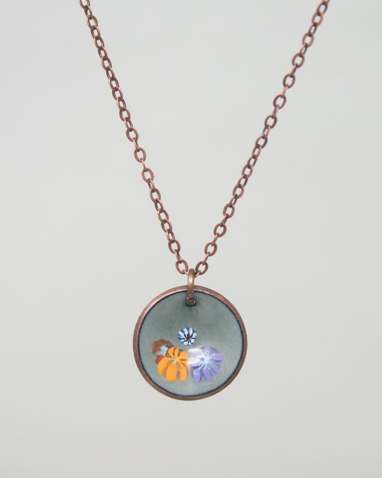 a necklace with a picture of a flower on it