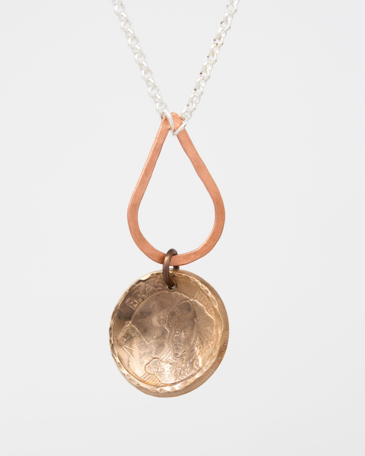 A necklace with a pendant featuring a bronze-colored metal design, possibly a coin or medallion, hanging from a chain.