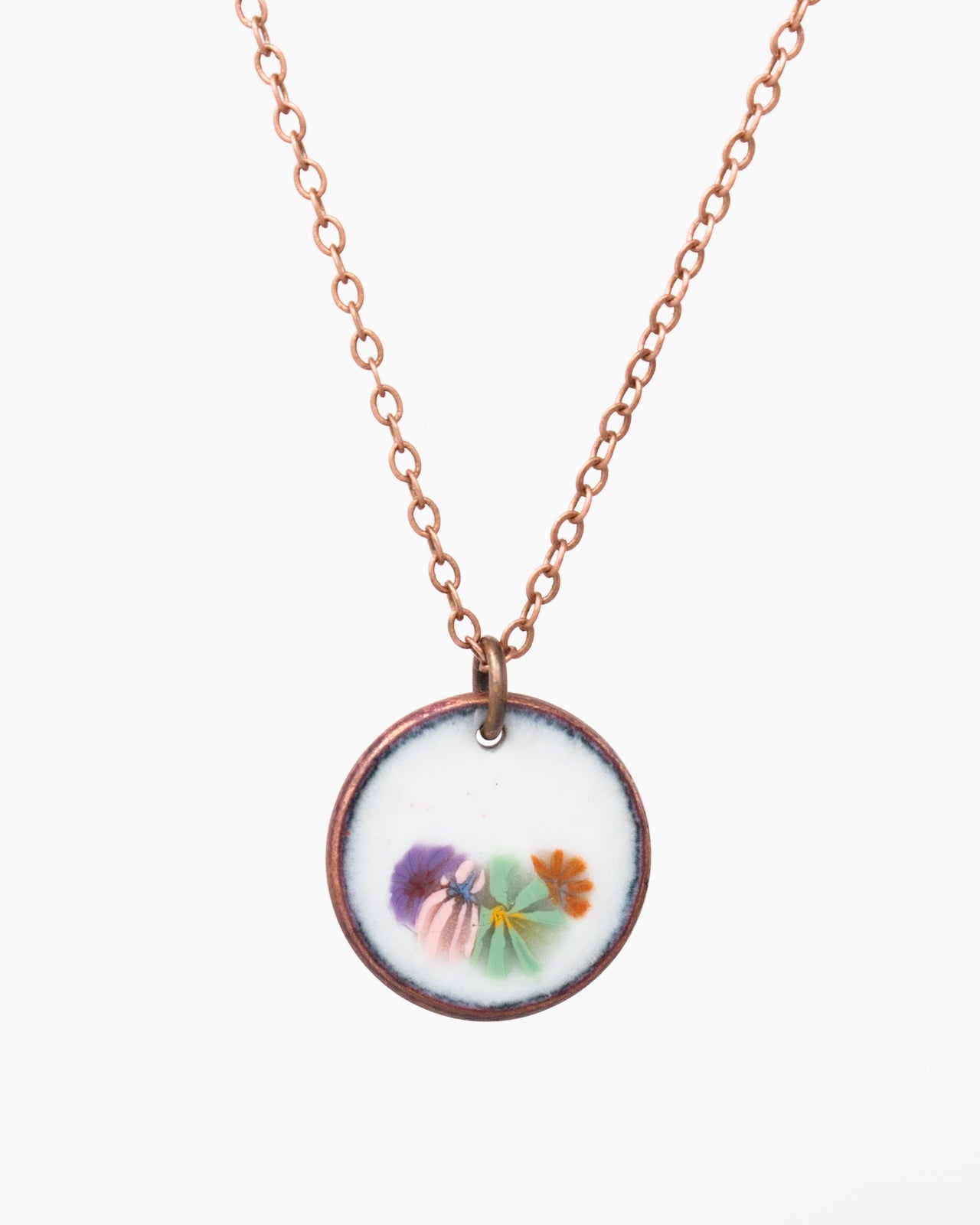 A necklace with a circular pendant featuring a floral design.