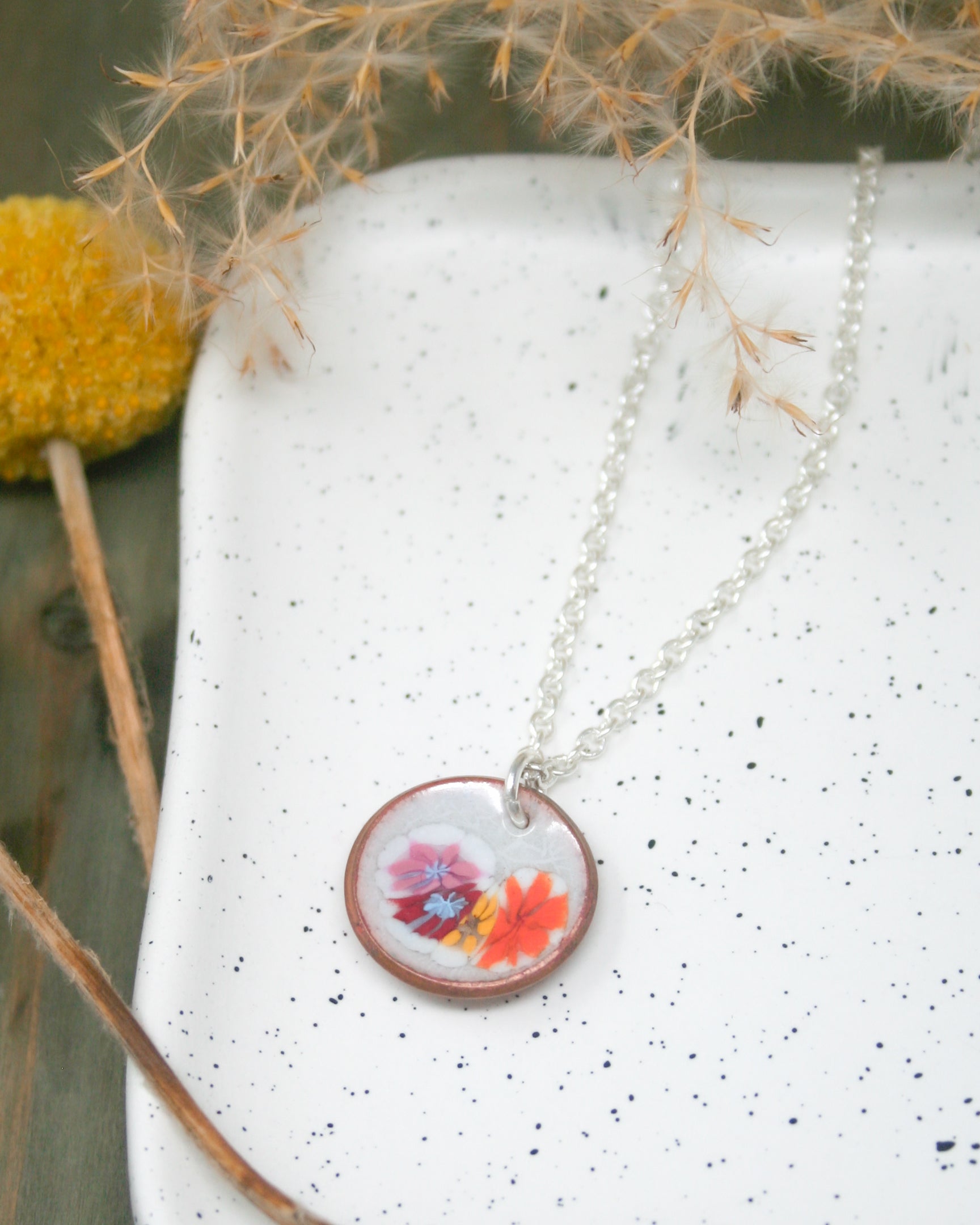 a necklace with a picture of a flower on it