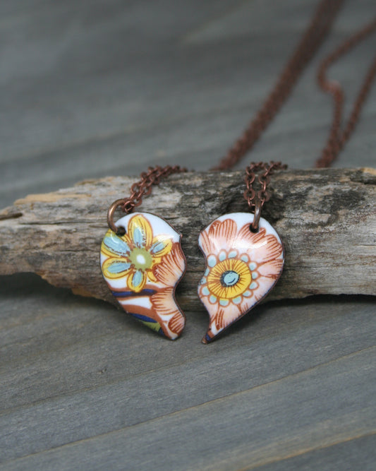 a couple of necklaces sitting on top of a piece of wood