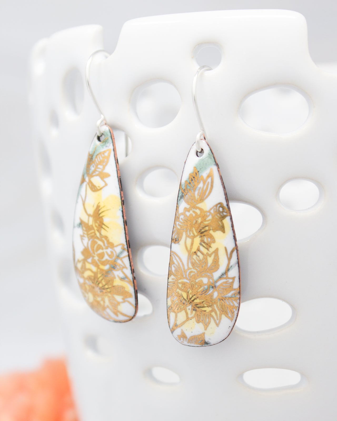 A pair of earrings with a floral design on a white background.
