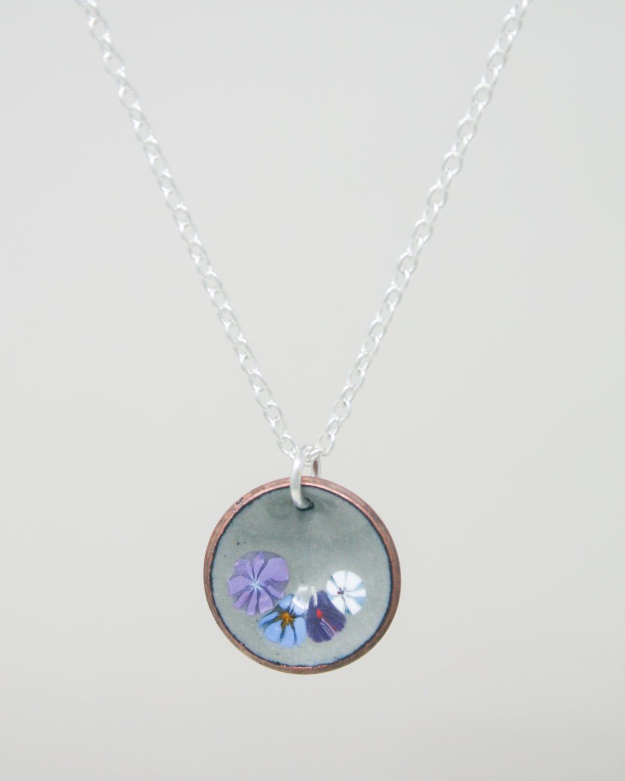 a necklace with a picture of flowers on it