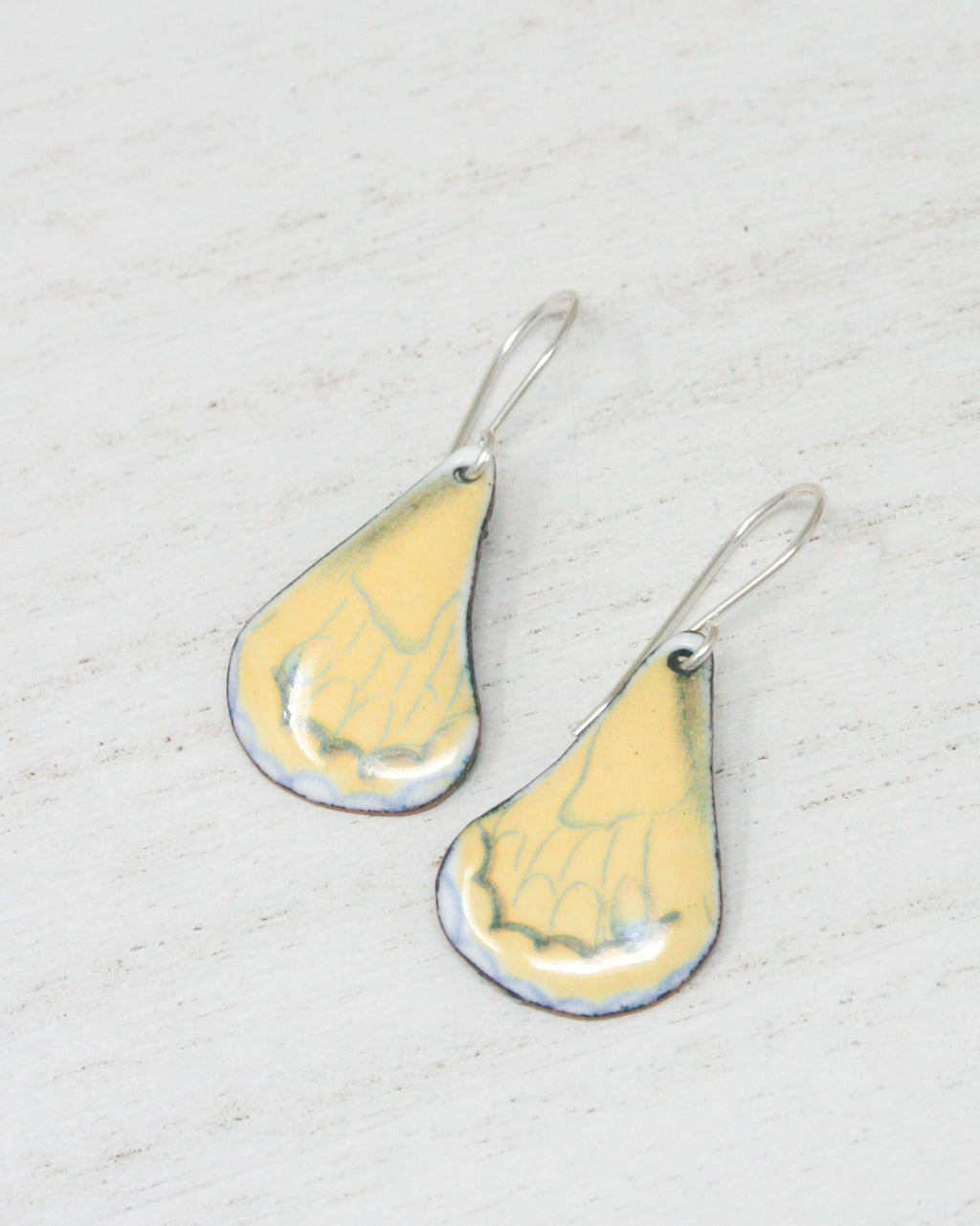 a pair of yellow and silver tear shaped earrings