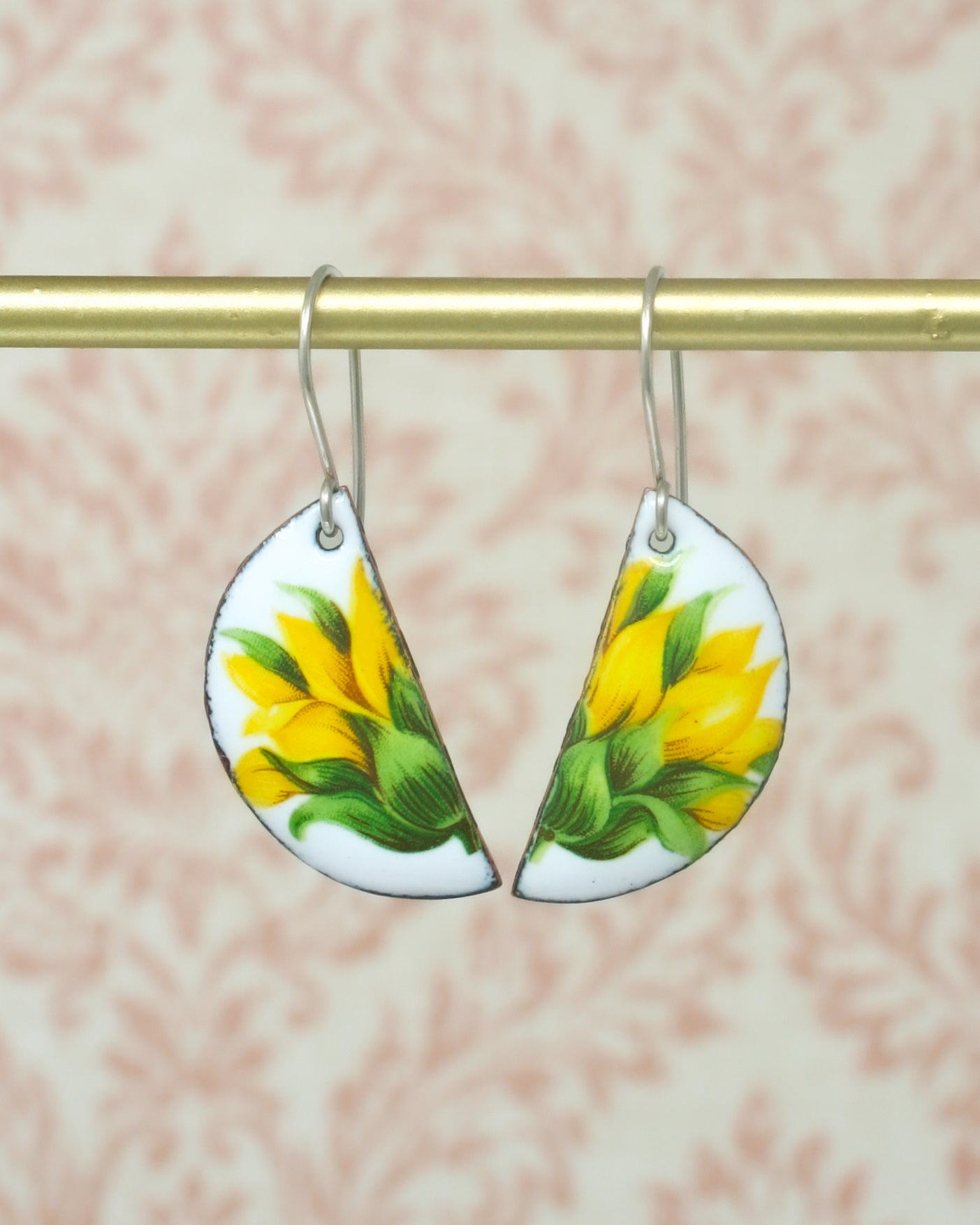 a pair of sunflowers painted on a pair of earrings