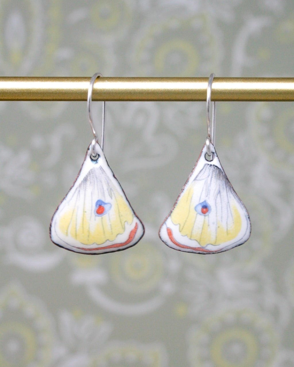 a pair of yellow and white butterfly shaped earrings