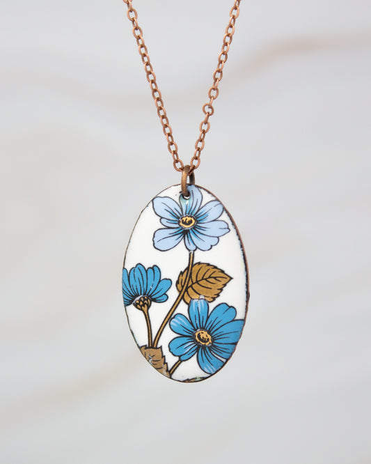 A necklace with a pendant featuring a floral design in blue and gold colors.
