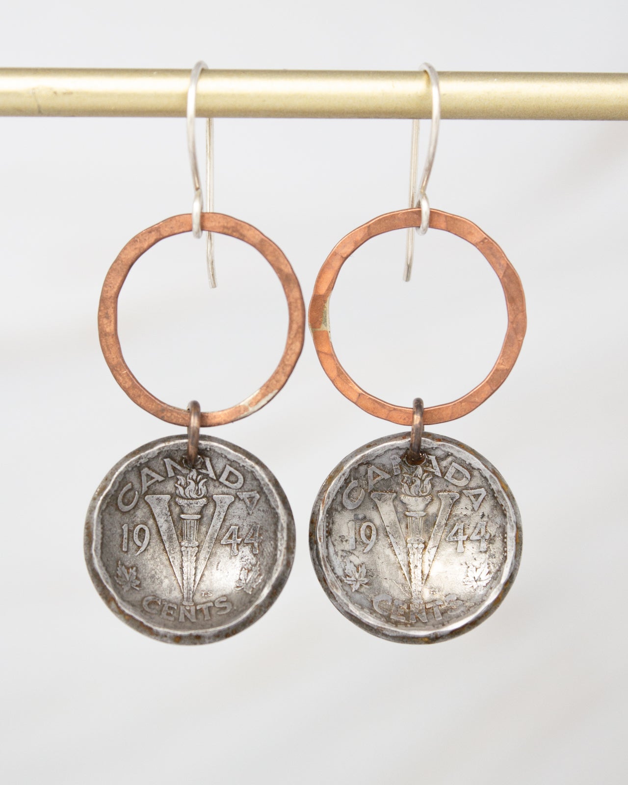 A pair of earrings made from two Canadian coins, featuring a combination of copper and silver tones.