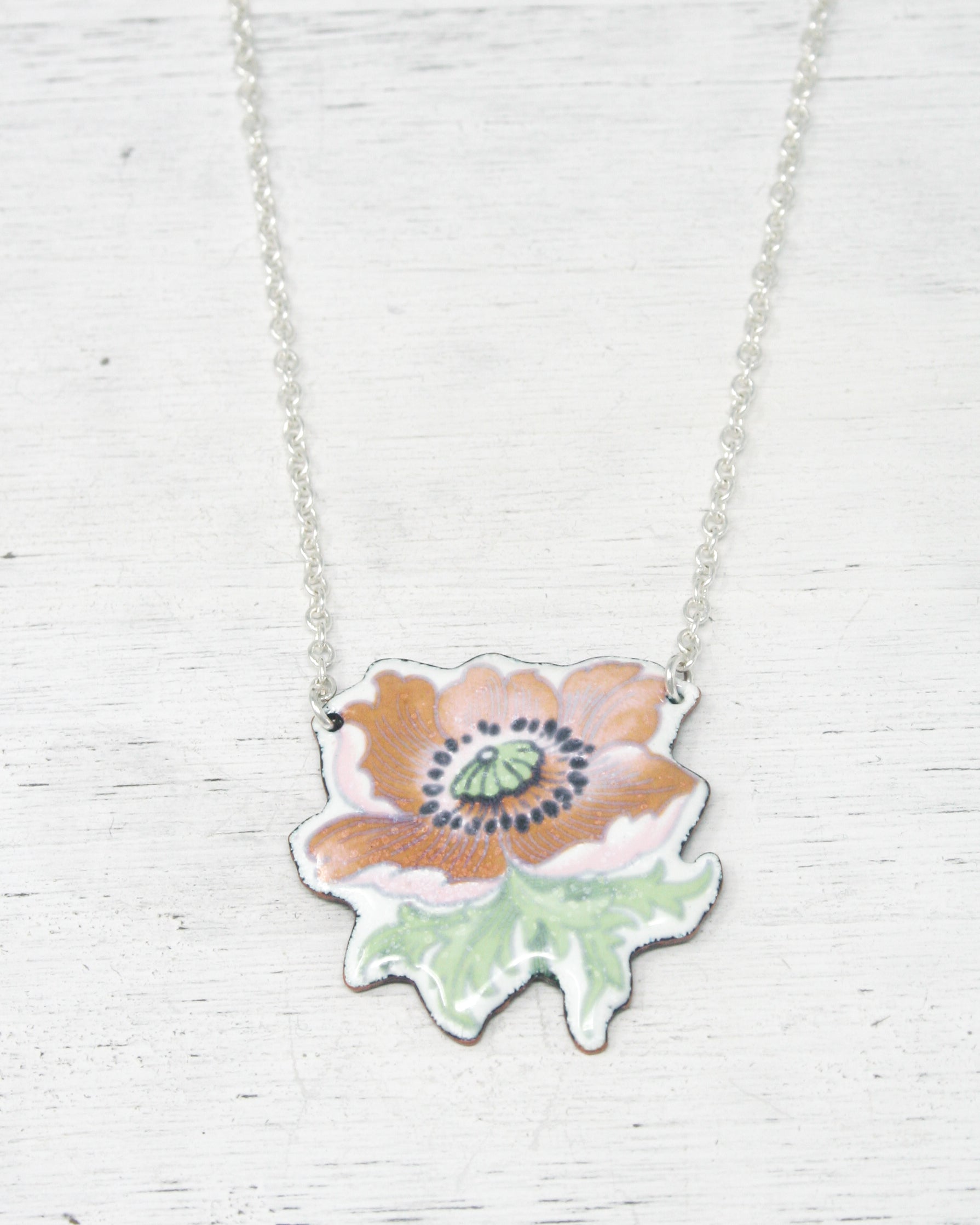 a necklace with a flower painted on it