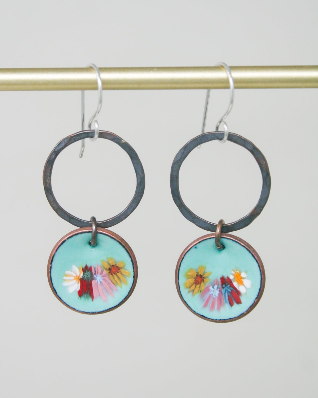 a pair of earrings hanging from a hook