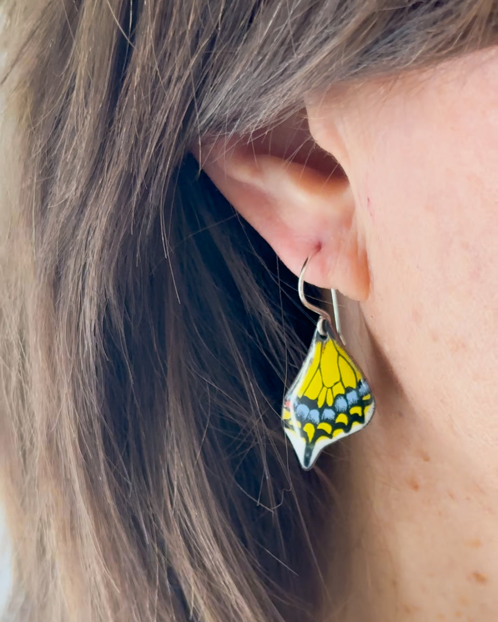 a close up of a person wearing a pair of earrings