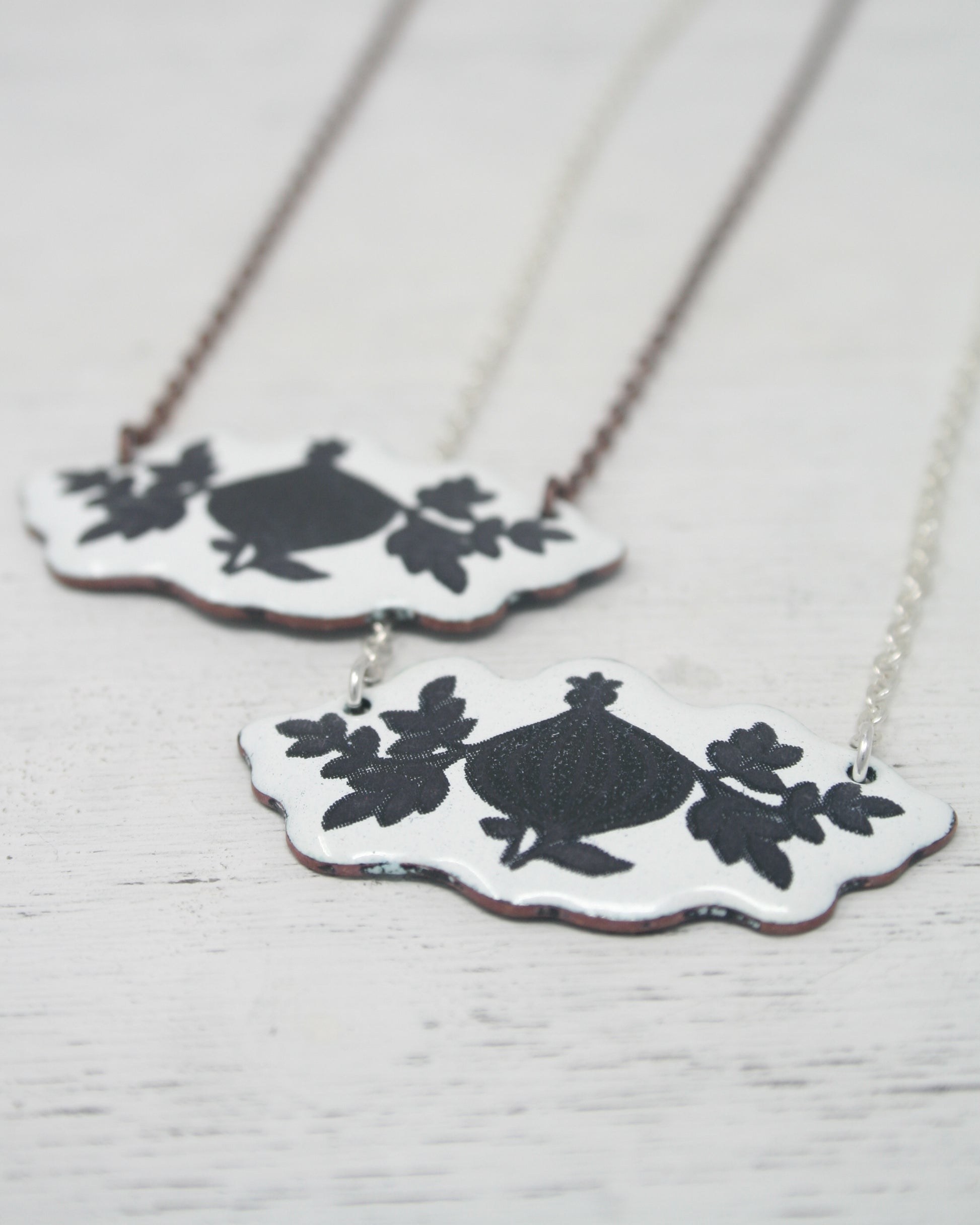 two necklaces with black and white designs on them