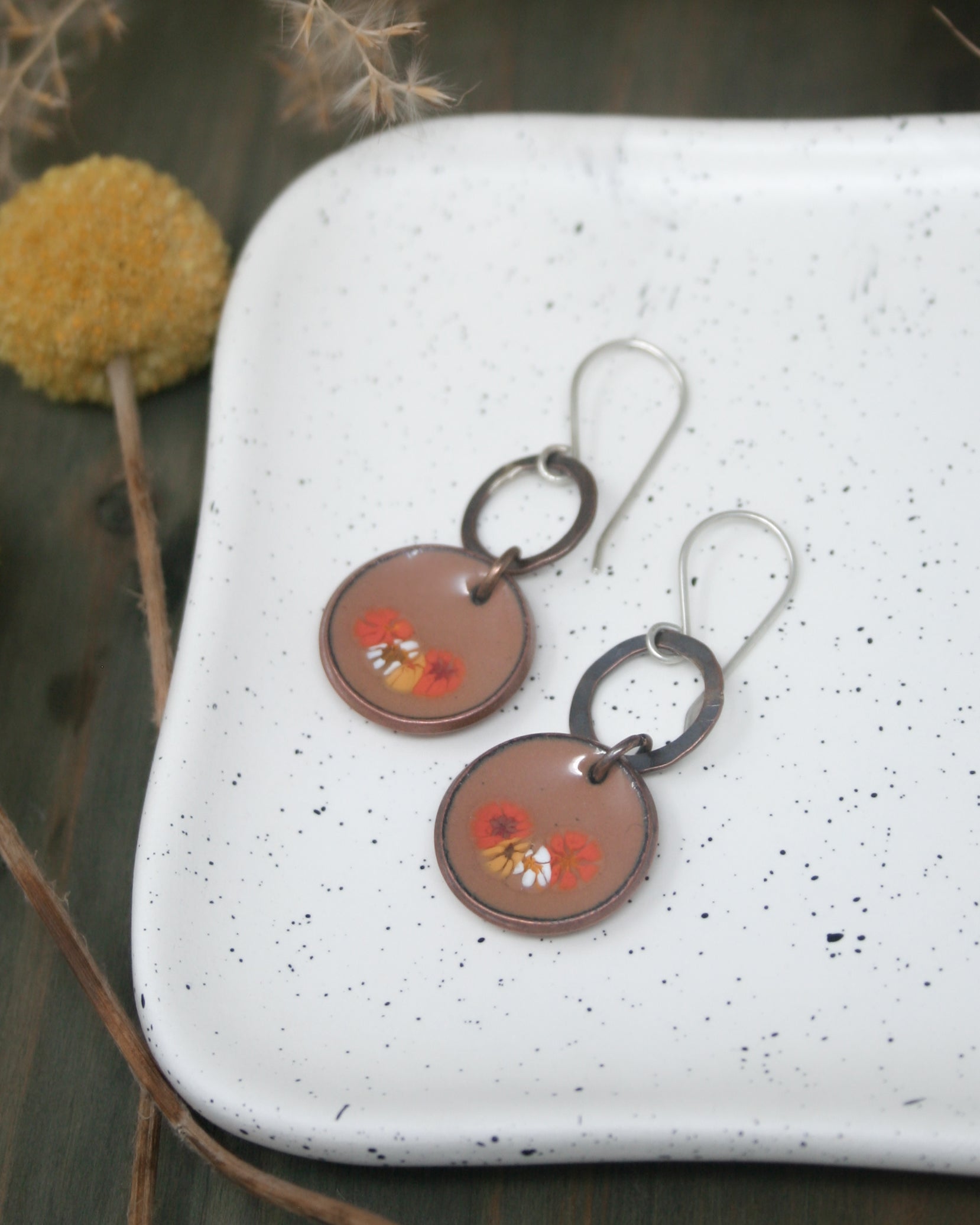 a pair of earrings sitting on top of a white plate