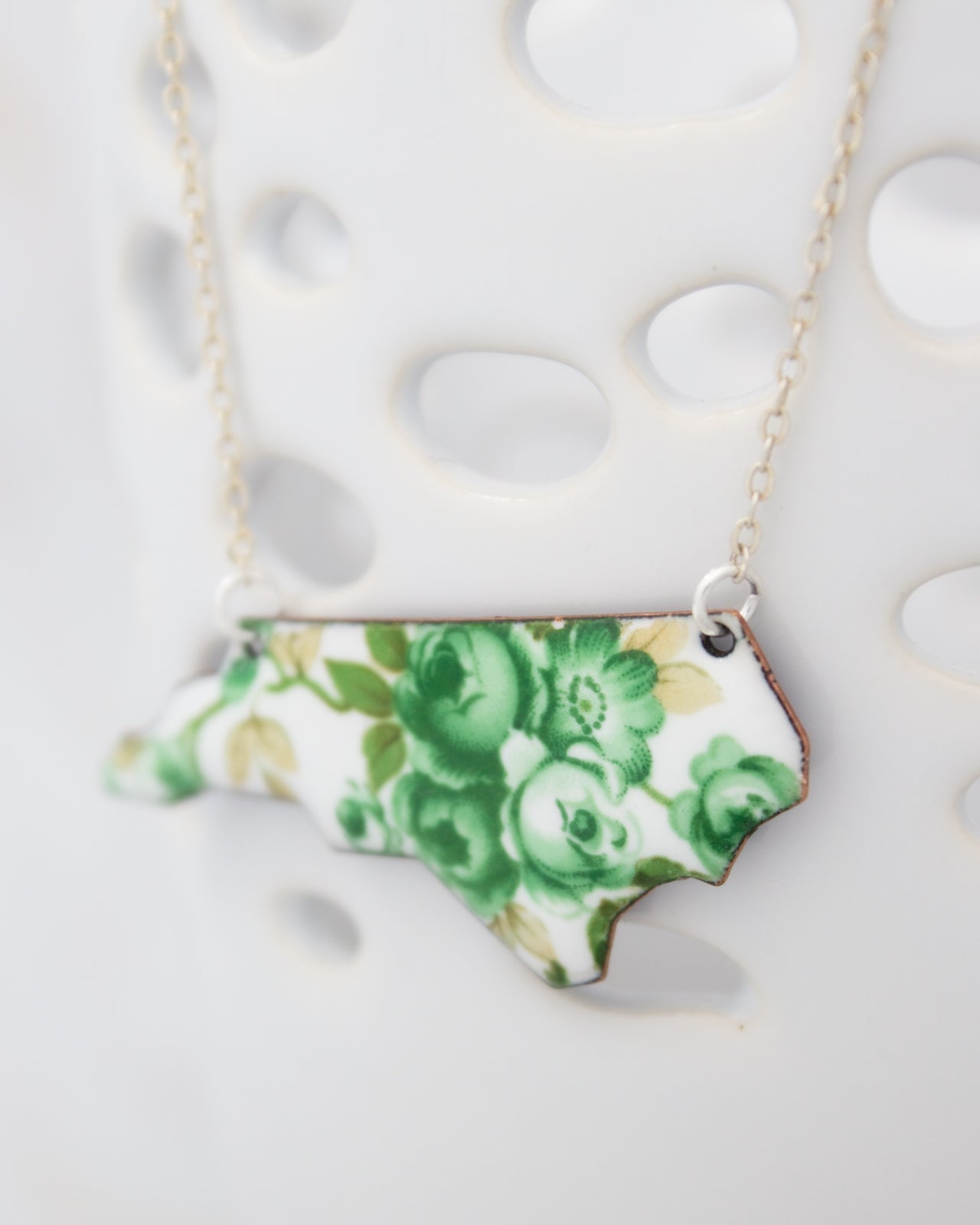 A necklace with a pendant in the shape of the state of North Carolina.