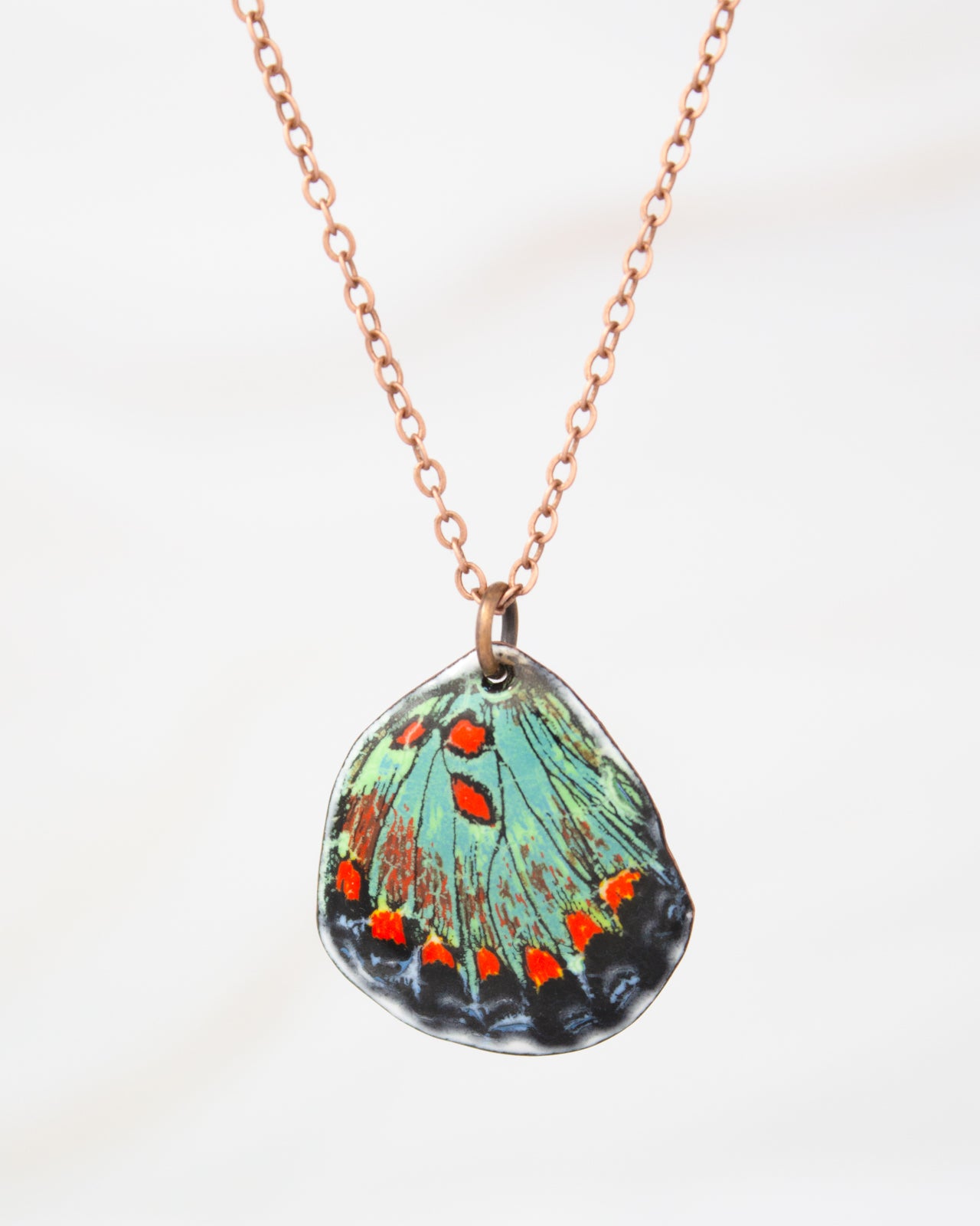 A necklace with a pendant featuring a colorful butterfly wing design.