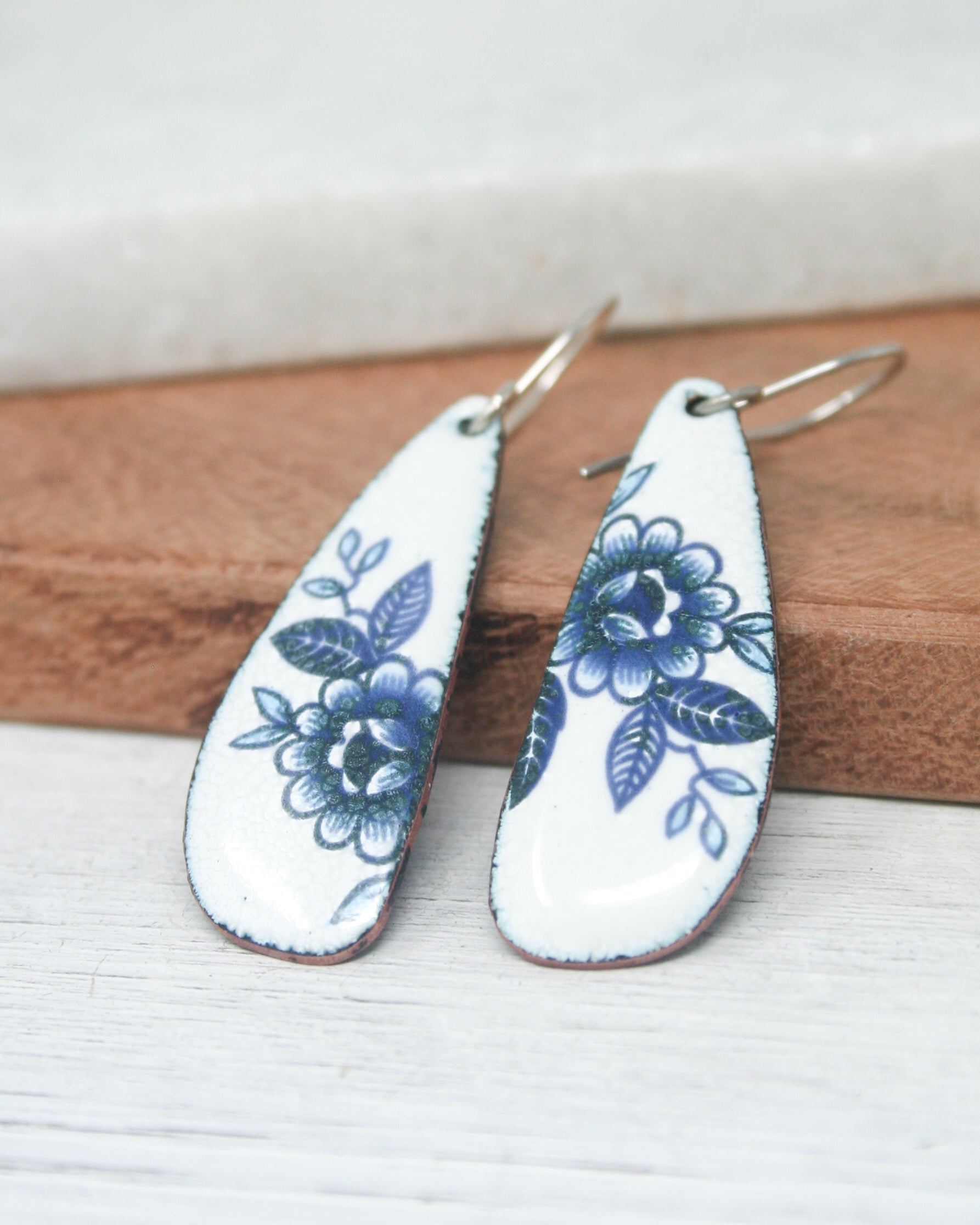 a pair of white and blue floral earrings