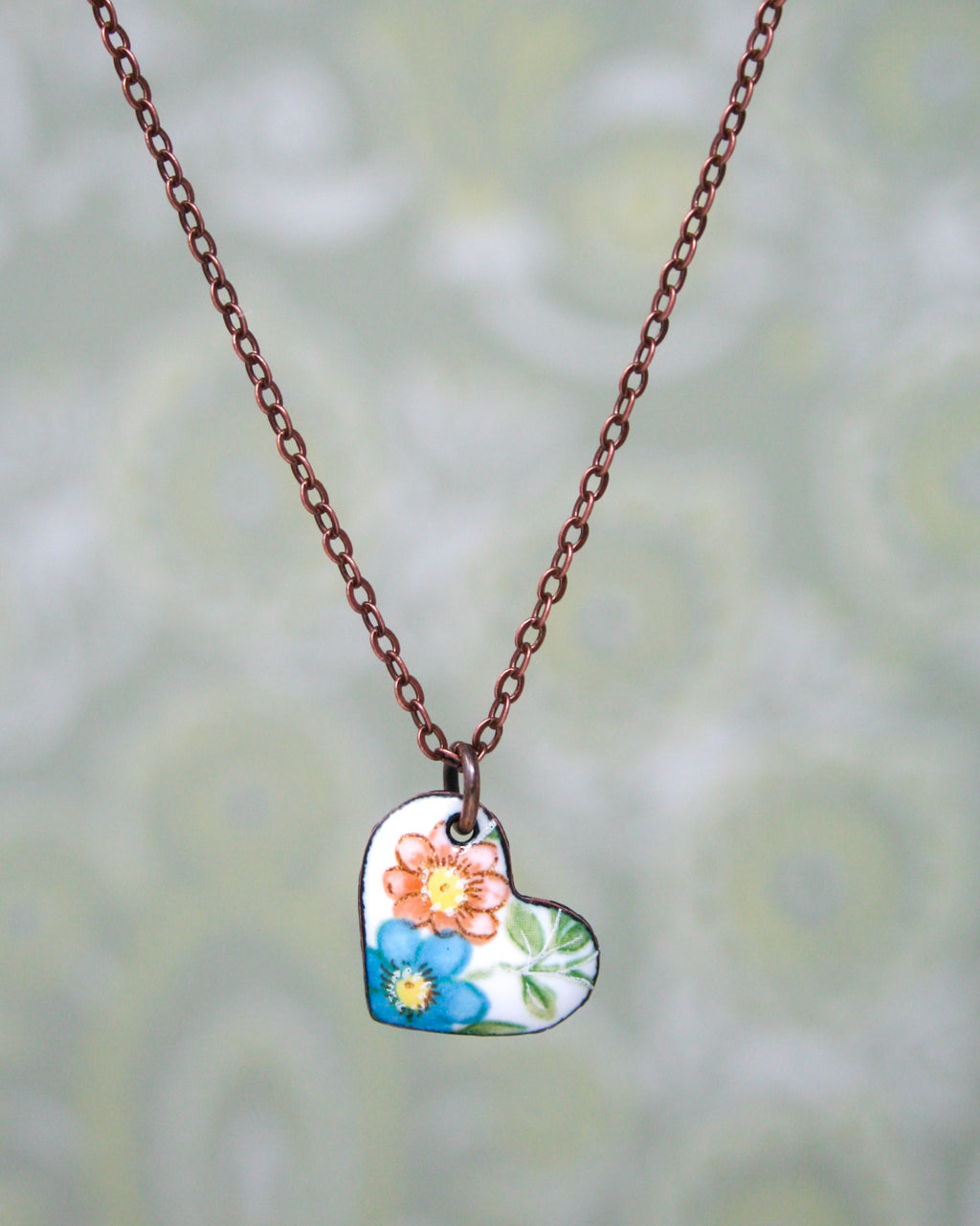 a necklace with a flowered heart on a chain