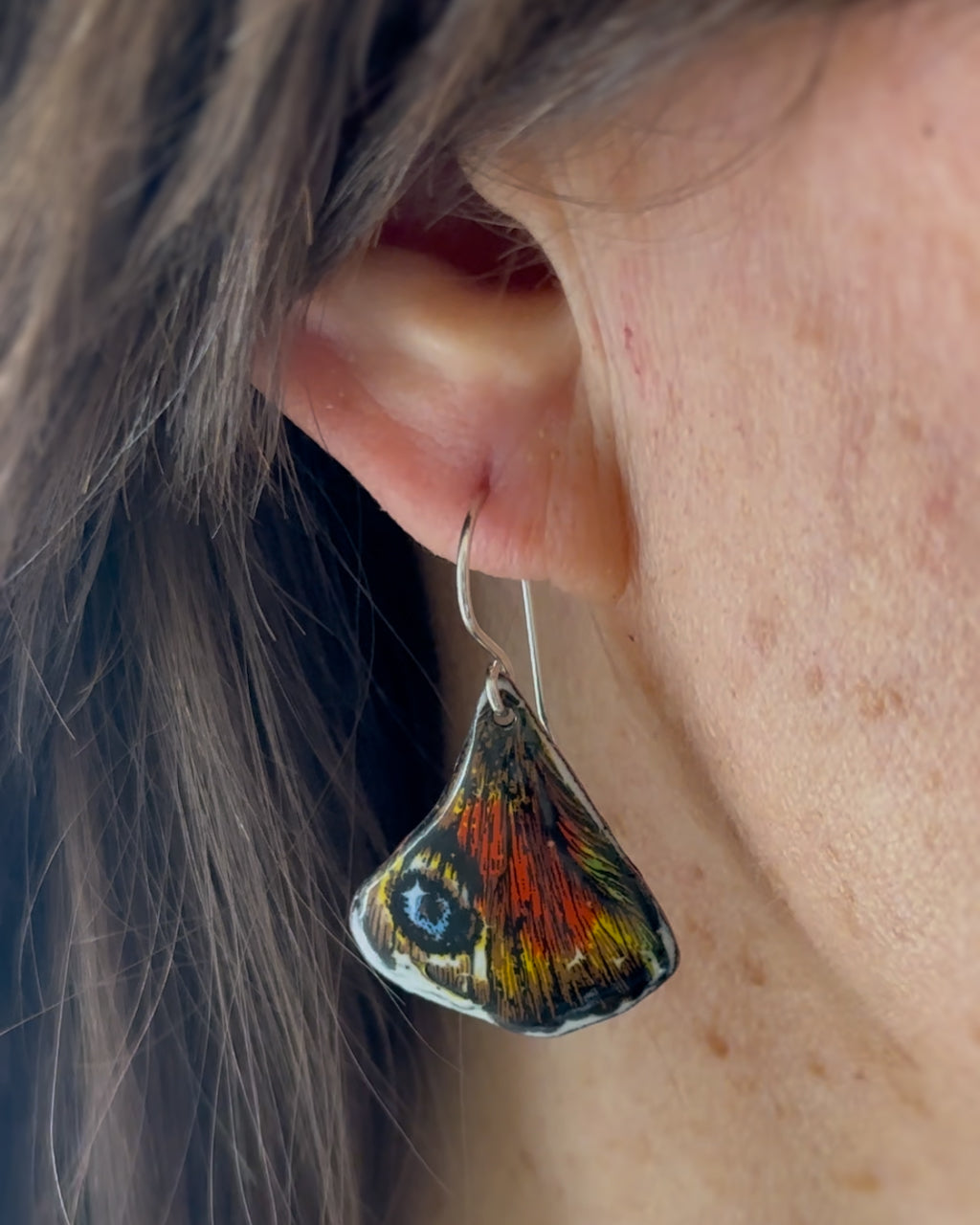 a close up of a person wearing a pair of earrings