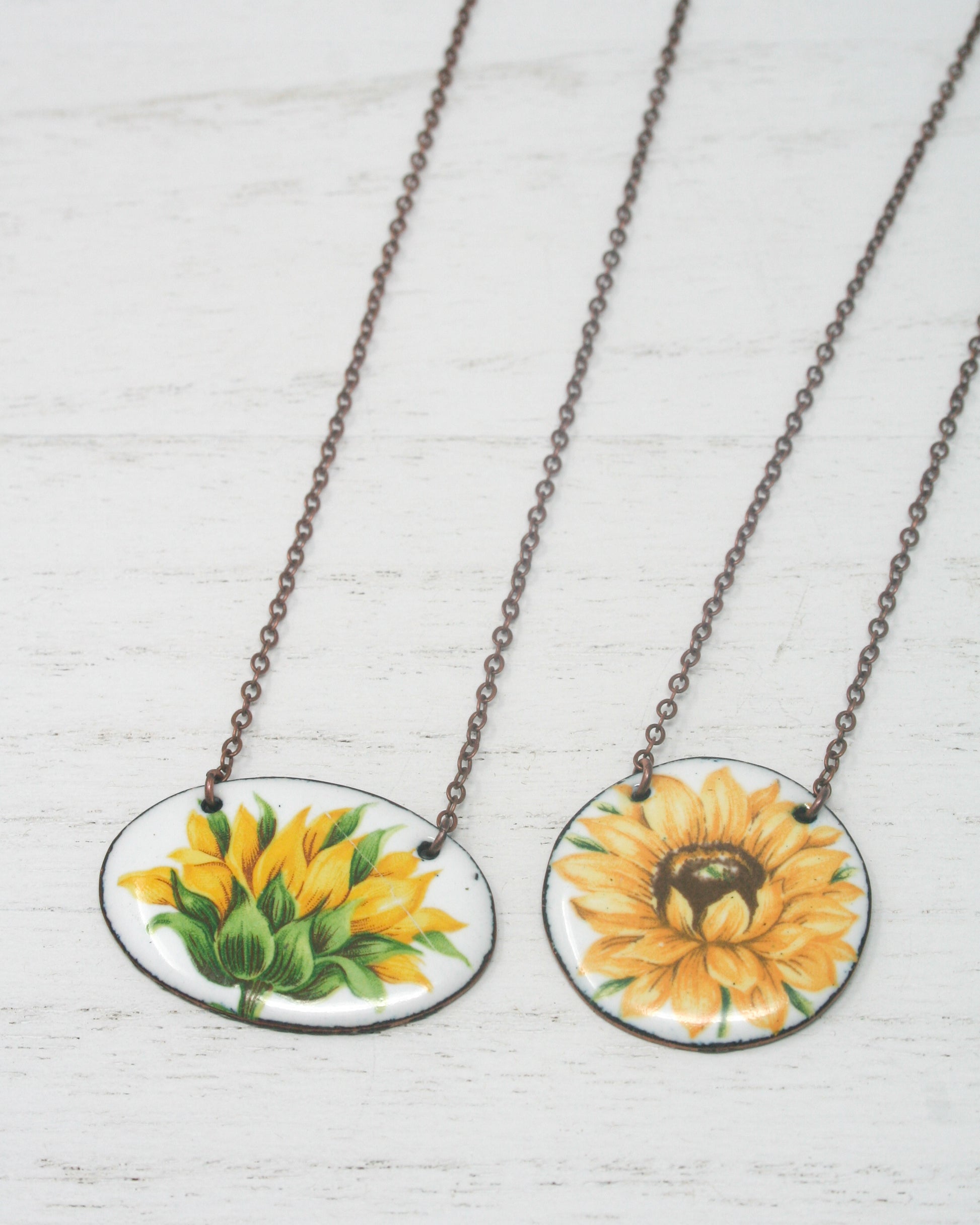 two necklaces with sunflowers painted on them