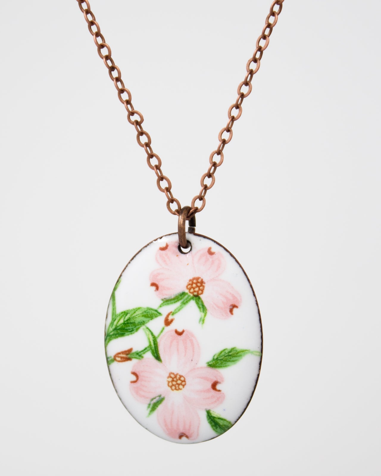 A necklace with a pendant featuring a floral design in pink and green colors.