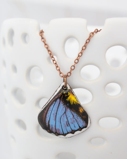 A necklace with a pendant featuring a colorful butterfly design.