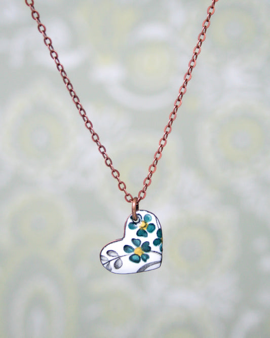 a necklace with a heart shaped pendant on a chain