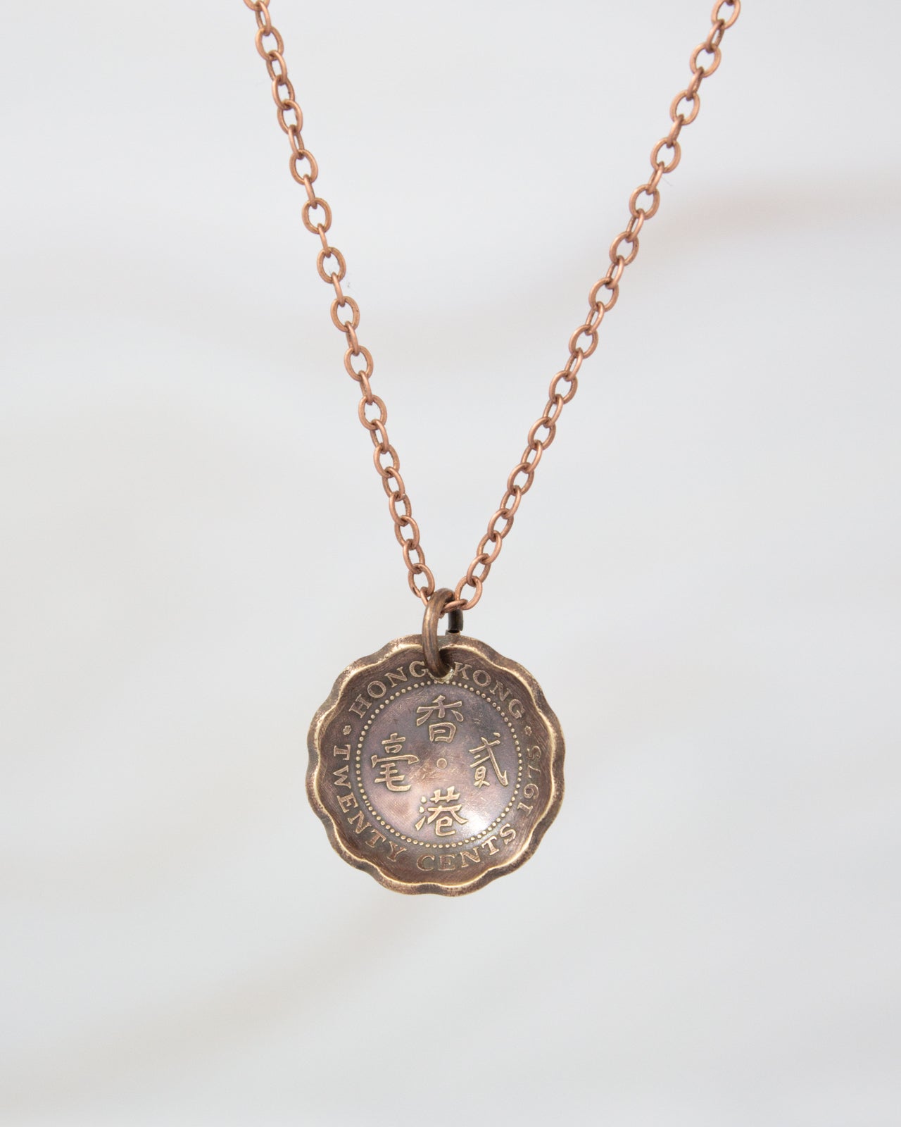 A necklace with a pendant featuring a coin or medallion design.