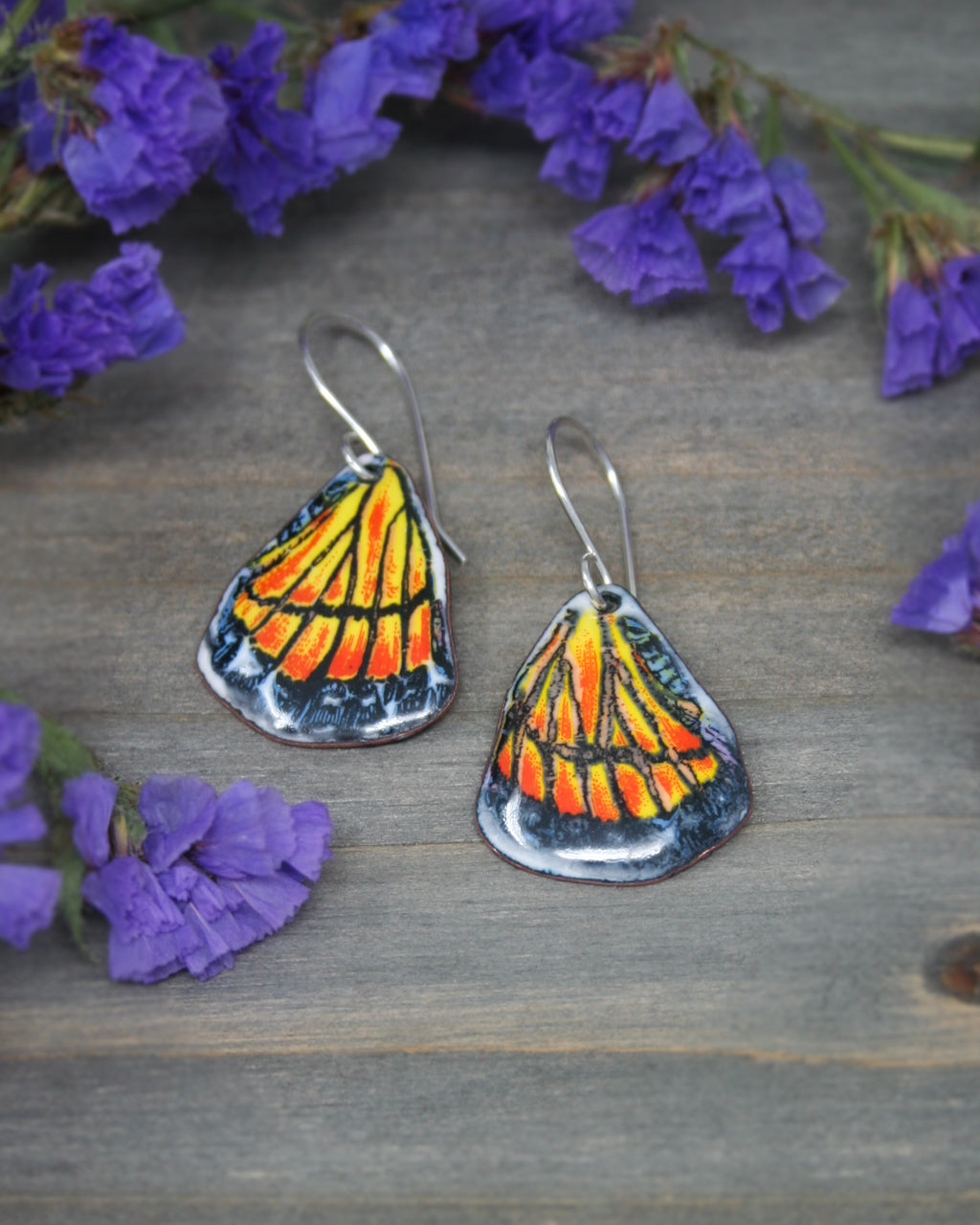 a pair of earrings with a butterfly on them