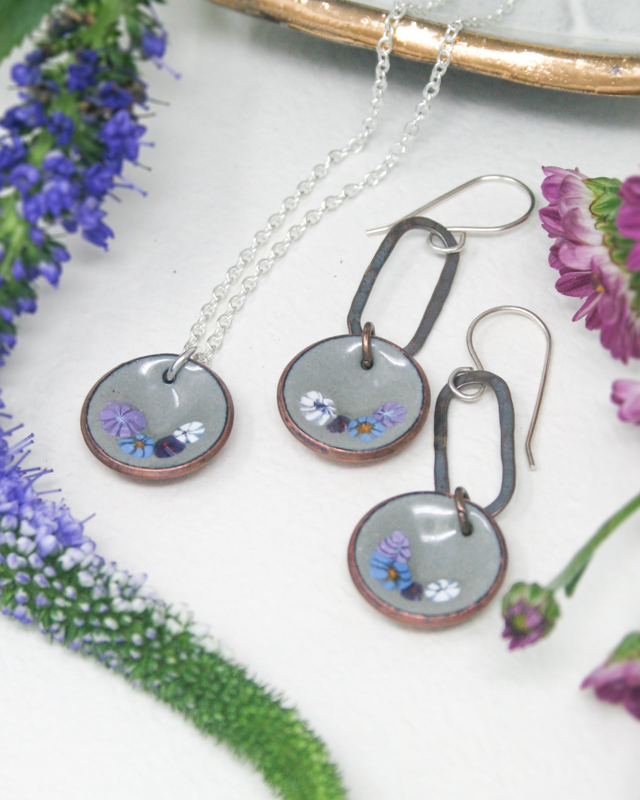 a pair of earrings and a necklace on a table