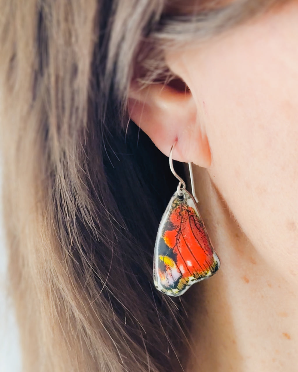 a close up of a person wearing a pair of earrings