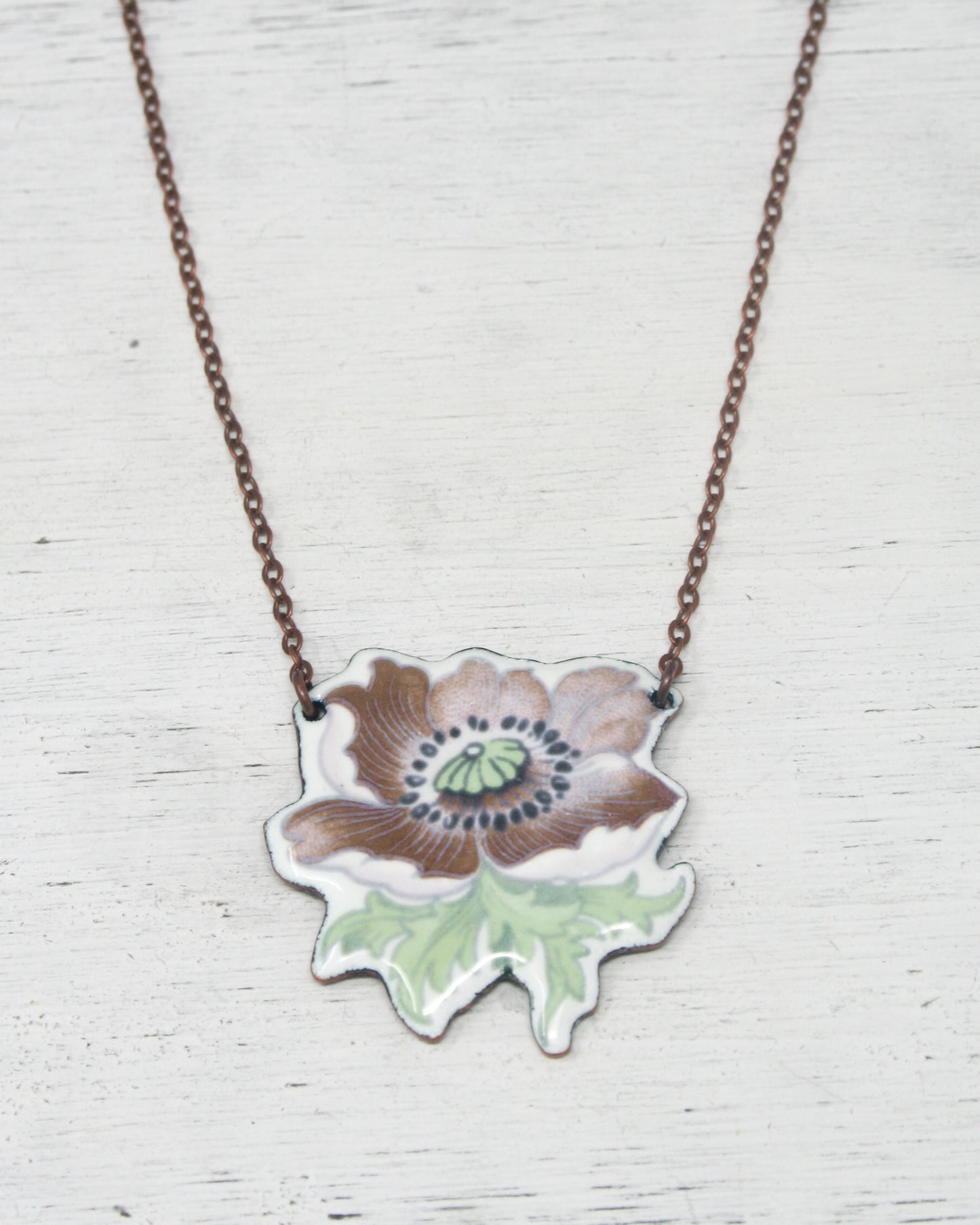 a necklace with a flower painted on it