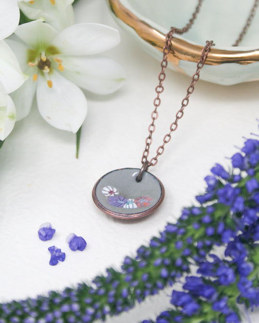 a necklace with a picture of a flower on it